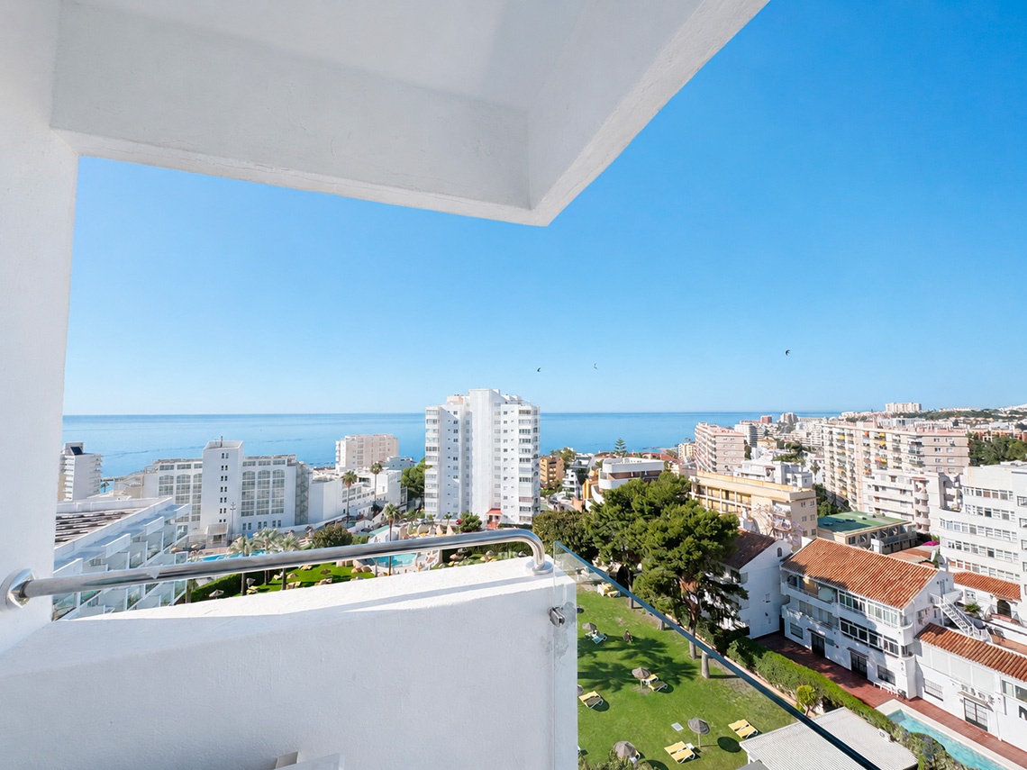 View from Dorobe: Hotel San Fermin balcony overlooking pool, buildings, and the sea.