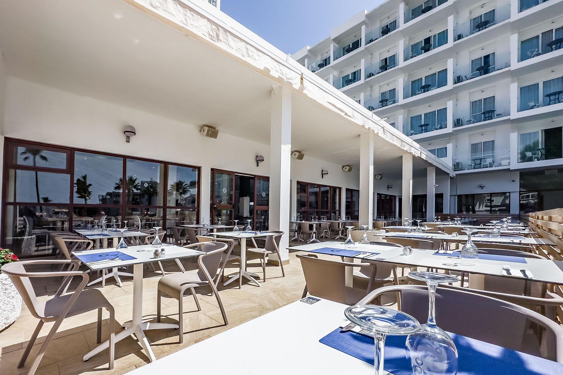 Dorobe: Hotel San Fermin. Terraza exterior con mesas y sillas, ideal para disfrutar del sol.