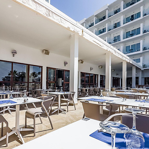 Terraza de restaurante de hotel con mesas puestas y vista al mar. Dorobe: Hotel San Fermin