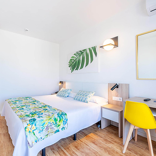 Habitación doble moderna con cama cómoda,Dorobe: Hotel San Fermin decoración tropical y escritorio.