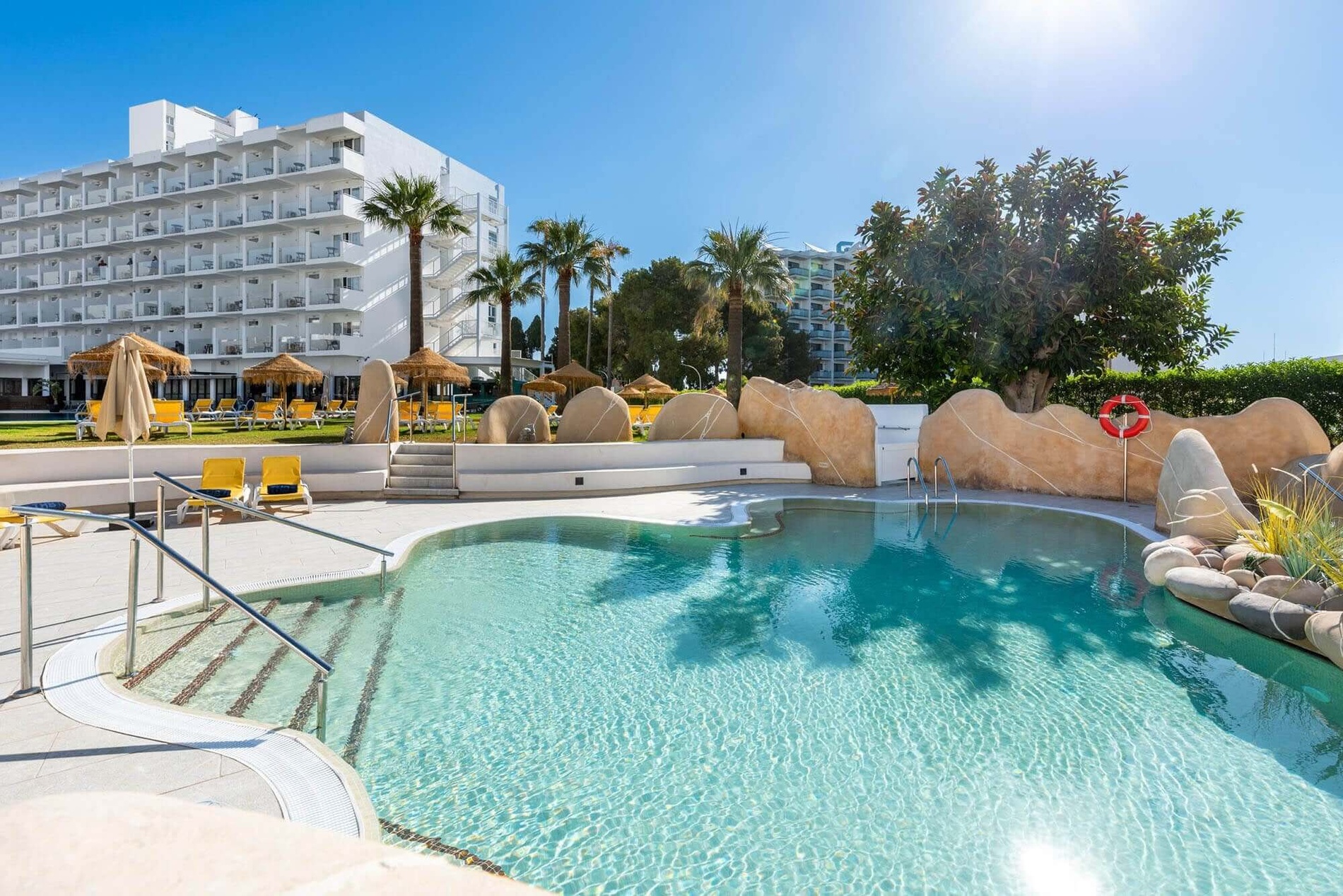 Dorobe Hotel San Fermin: Sunny outdoor pool, modern hotel, palm trees & sun loungers.