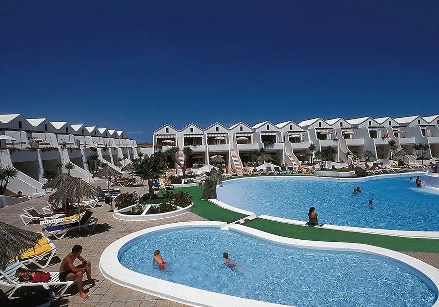 Pareja relajándose en Sands Beach, con vistas a la playa y hoteles.