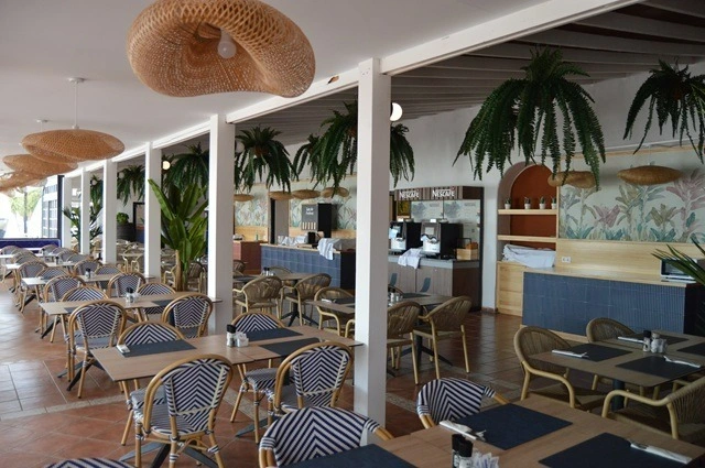 Mesera arregla mesa en restaurante de Sands Beach Club.