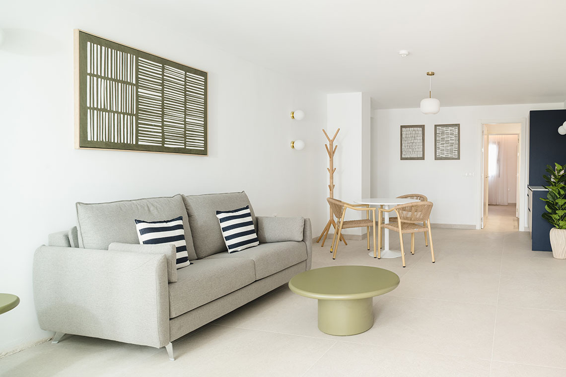 Modern bedroom with king bed, patterned wall, and TV. Sands Beach