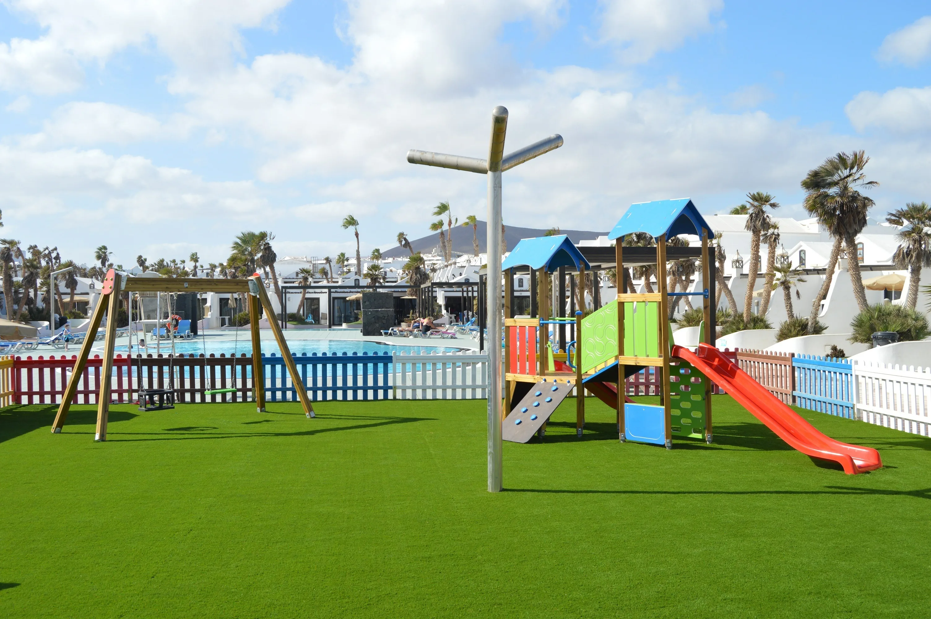 Parque infantil en Sands Beach con toboganes, columpios y caballos balancín.