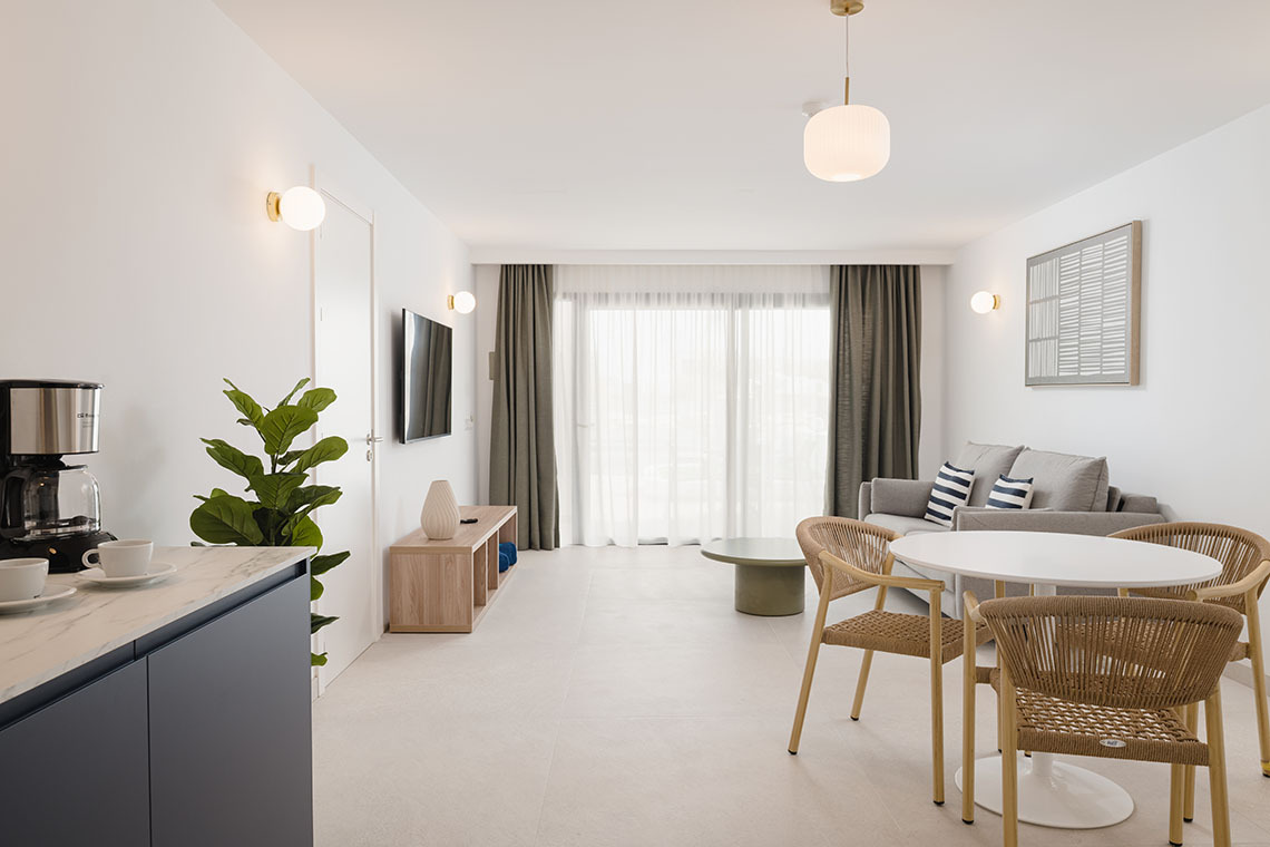 Modern bedroom with king bed, patterned wall, and TV. Sands Beach