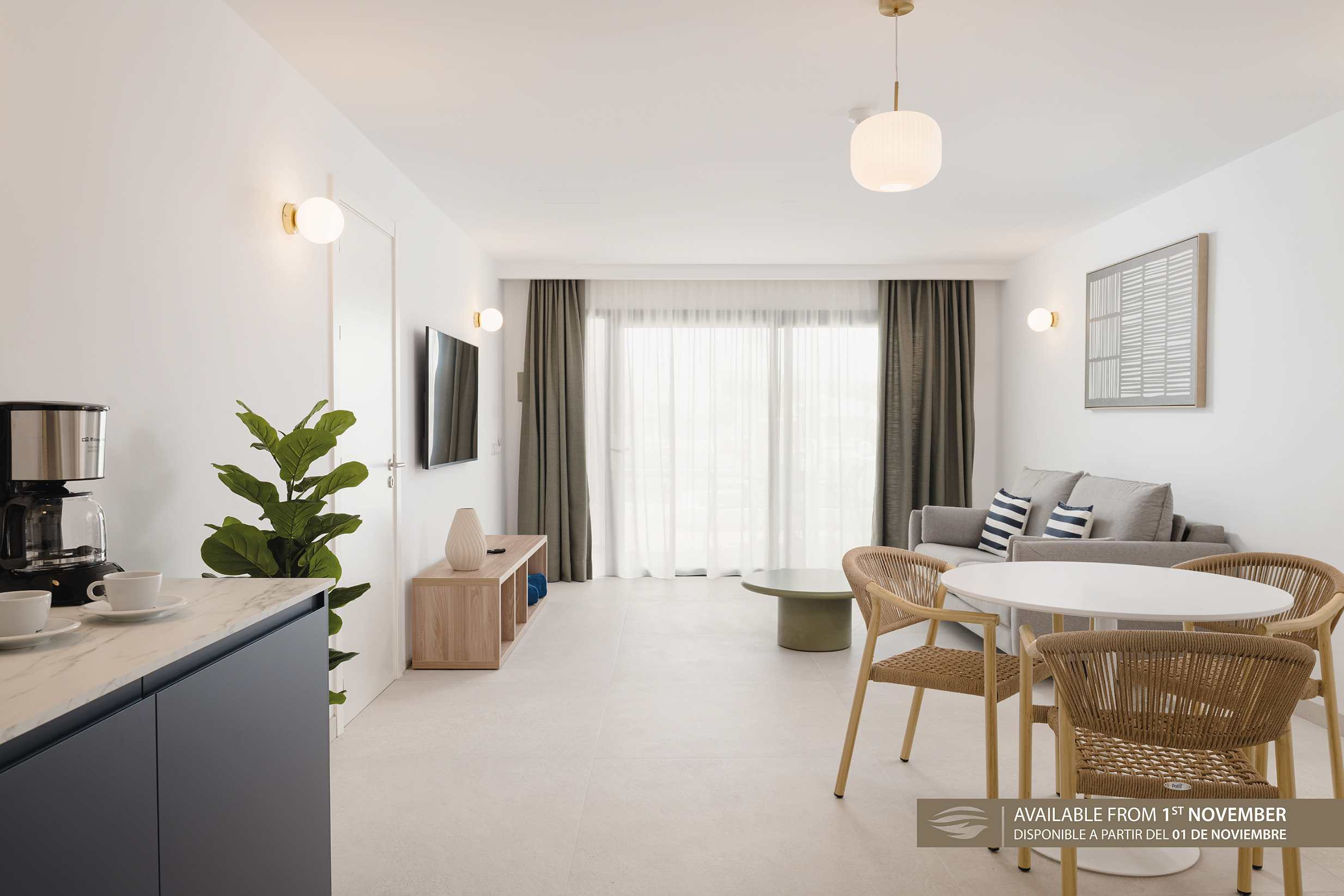 Estudio luminoso con cafetera, sofá y mesa de comedor. Sands BeachDisponible desde el 1 de noviembre.