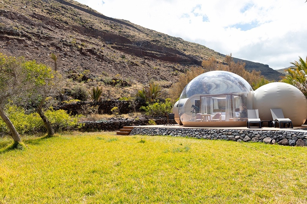 dos hombres y dos mujeres caminan por la playa con tablas de surf