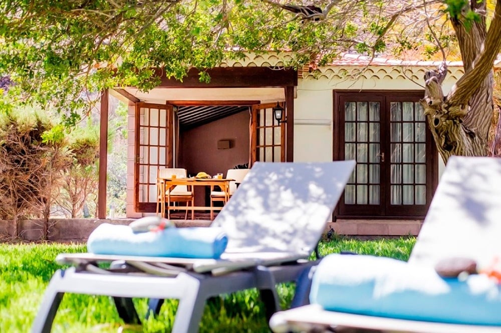 una mujer en traje de baño y sombrero se sienta junto a una piscina