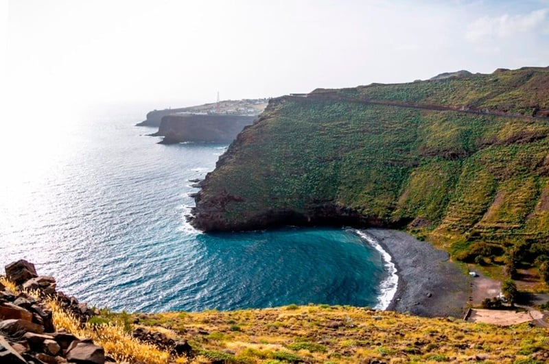 una mujer en traje de baño y sombrero se sienta en el borde de una piscina