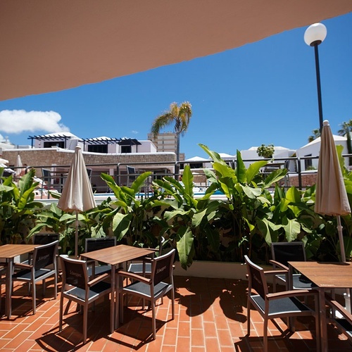 tables and chairs on a patio with a sign that says ' santander ' on it