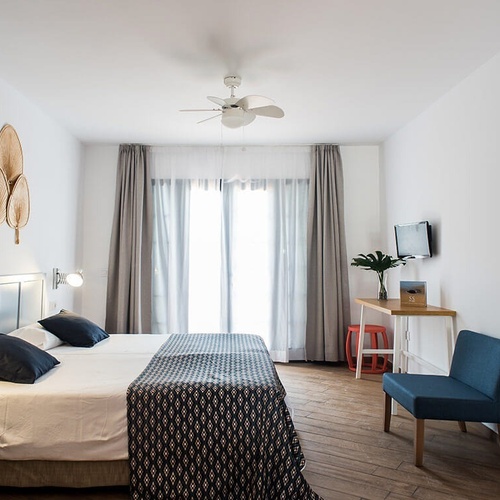 a bedroom with two beds and a ceiling fan