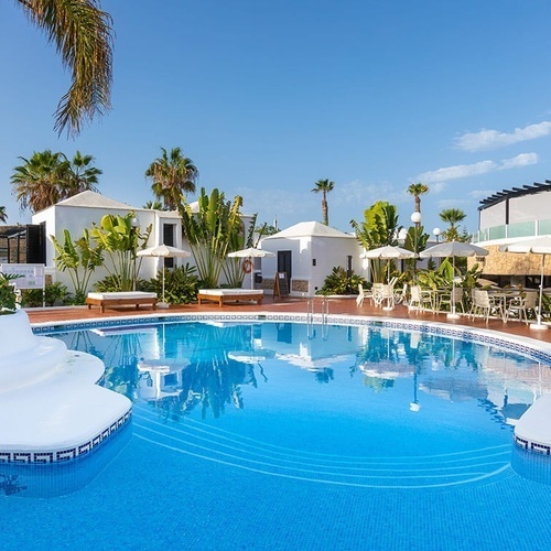 a large swimming pool is surrounded by chairs and umbrellas