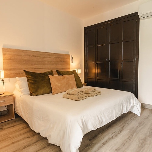 a bedroom with a king size bed and a nightstand