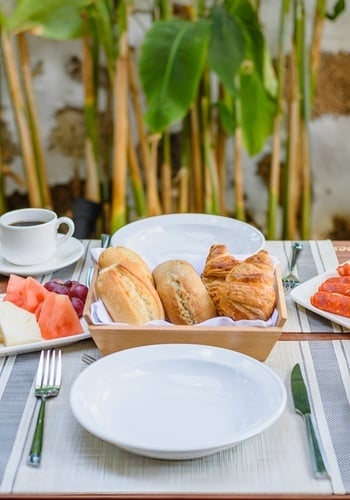 un hombre con una camisa blanca con la palabra aida en el pecho está sirviendo a una mujer con un sombrero de paja