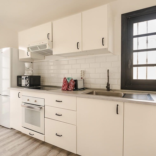 a kitchen with white cabinets and a black window