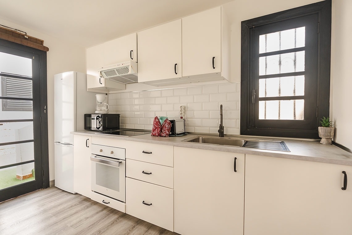 a kitchen with white cabinets and a black window