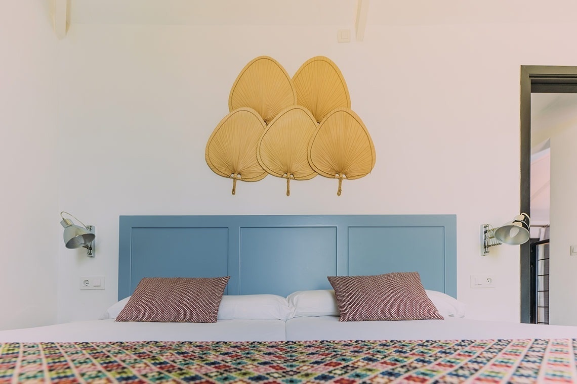 a bed with a blue headboard and white sheets