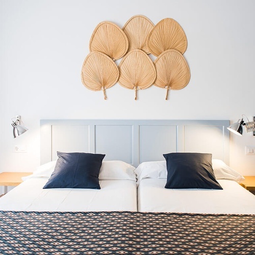 una habitación con una cama blanca y almohadas azules