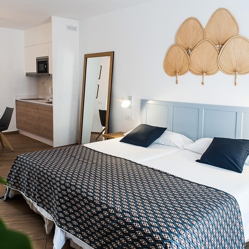 a bedroom with a bed a table and a mirror