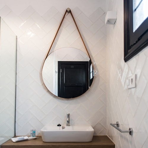 a bathroom with a sink and a round mirror
