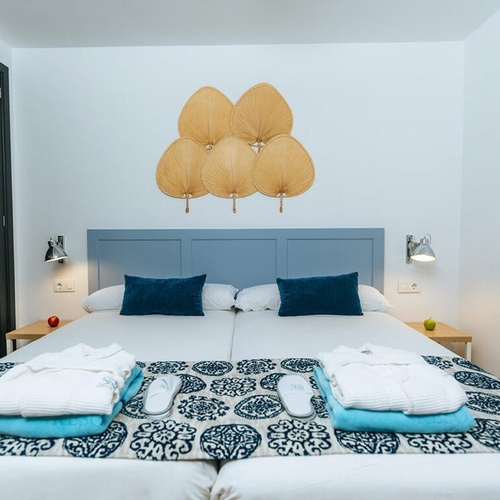 a bed with a blue headboard and blue pillows