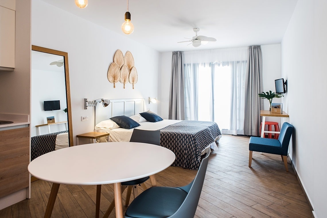 a bedroom with two beds and a table and chairs