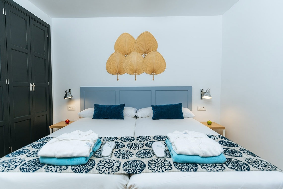 a bed with a blue headboard and blue pillows