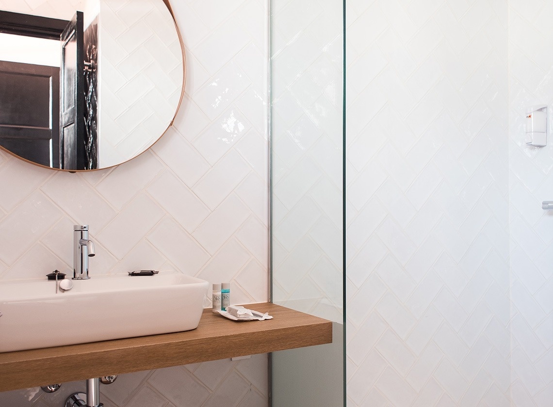 a bathroom with a sink and a round mirror
