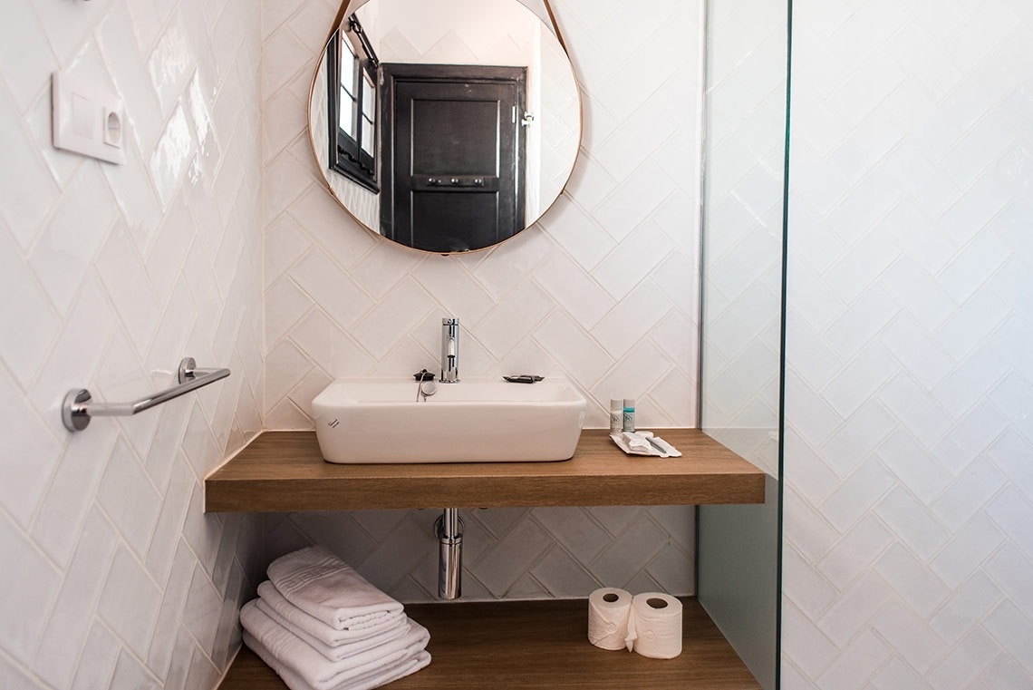 a bathroom with a sink and a round mirror