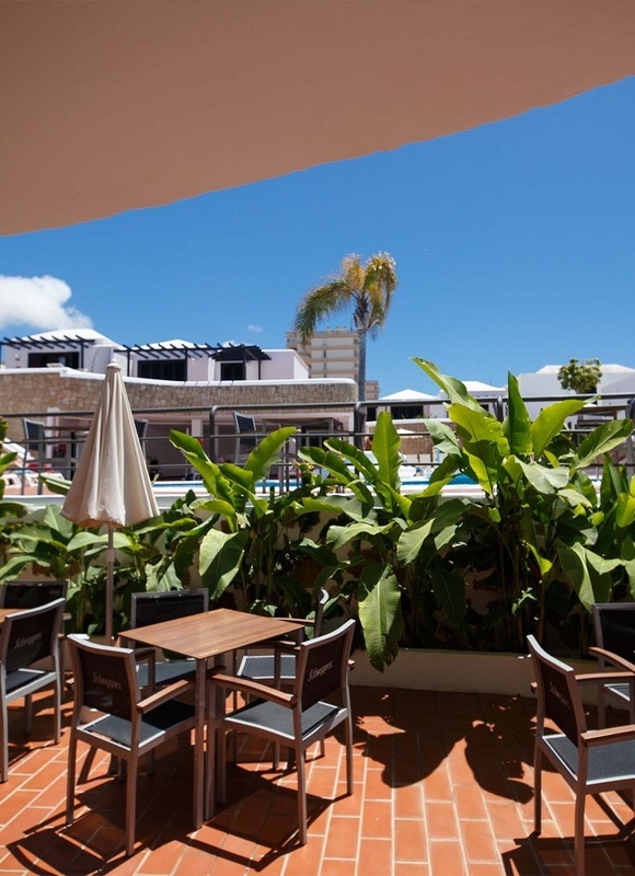 una terraza con mesas y sillas y un paraguas