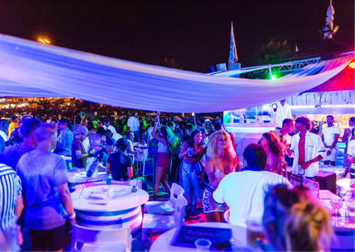 a restaurant with a chef preparing food in the background