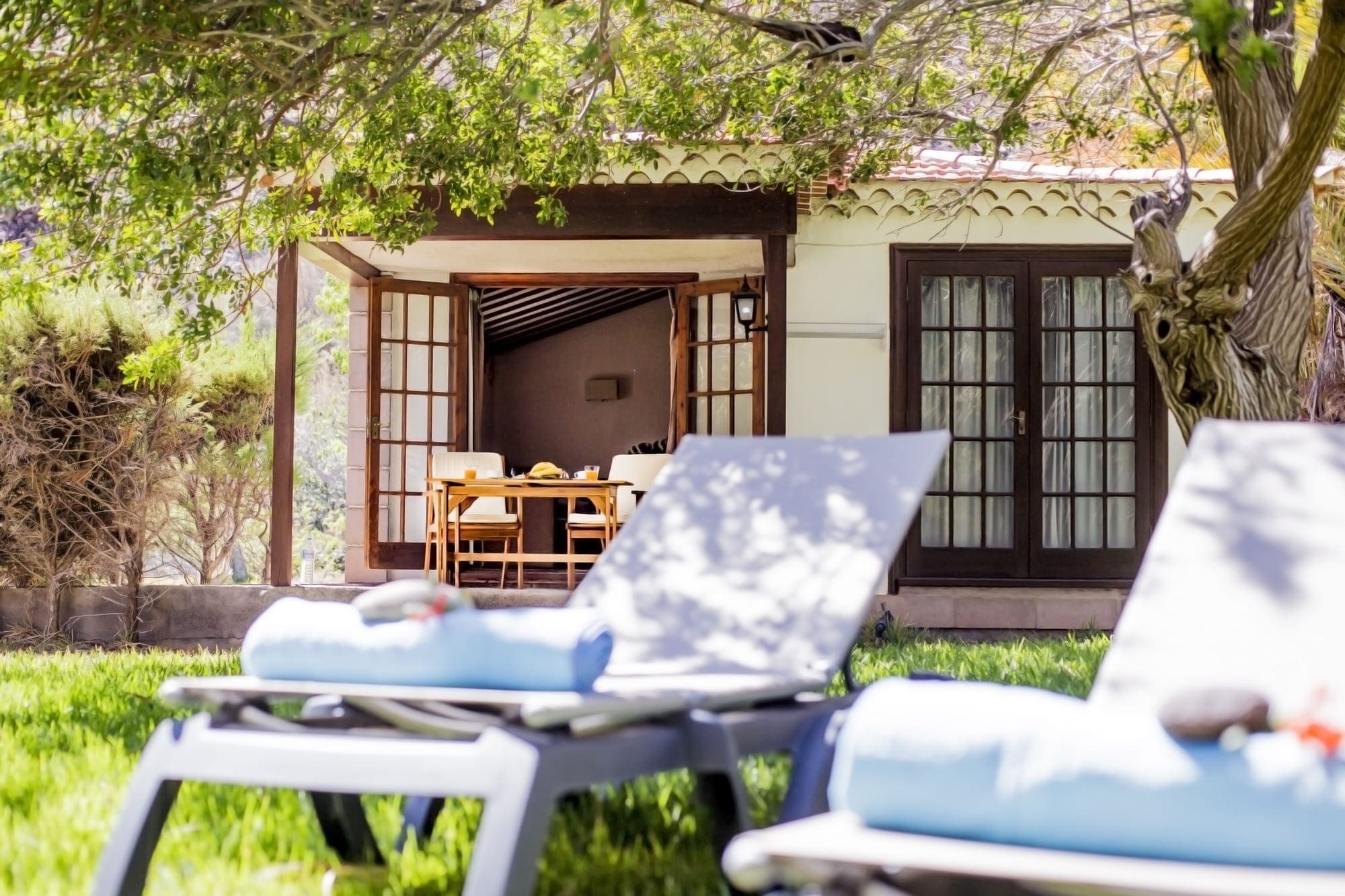 two lounge chairs are sitting in front of a house