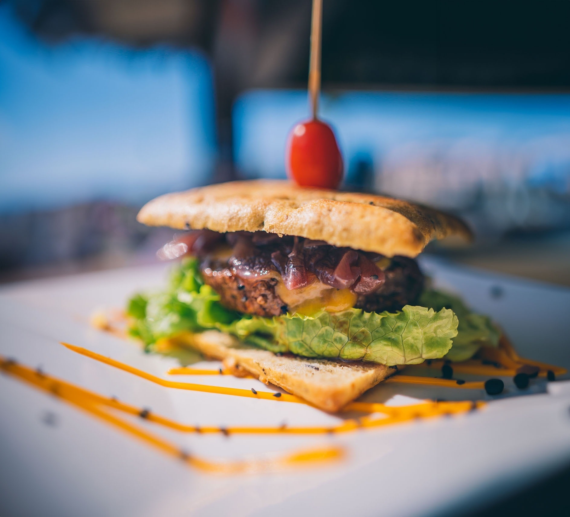 a close up of a sandwich on a plate with a tomato on top