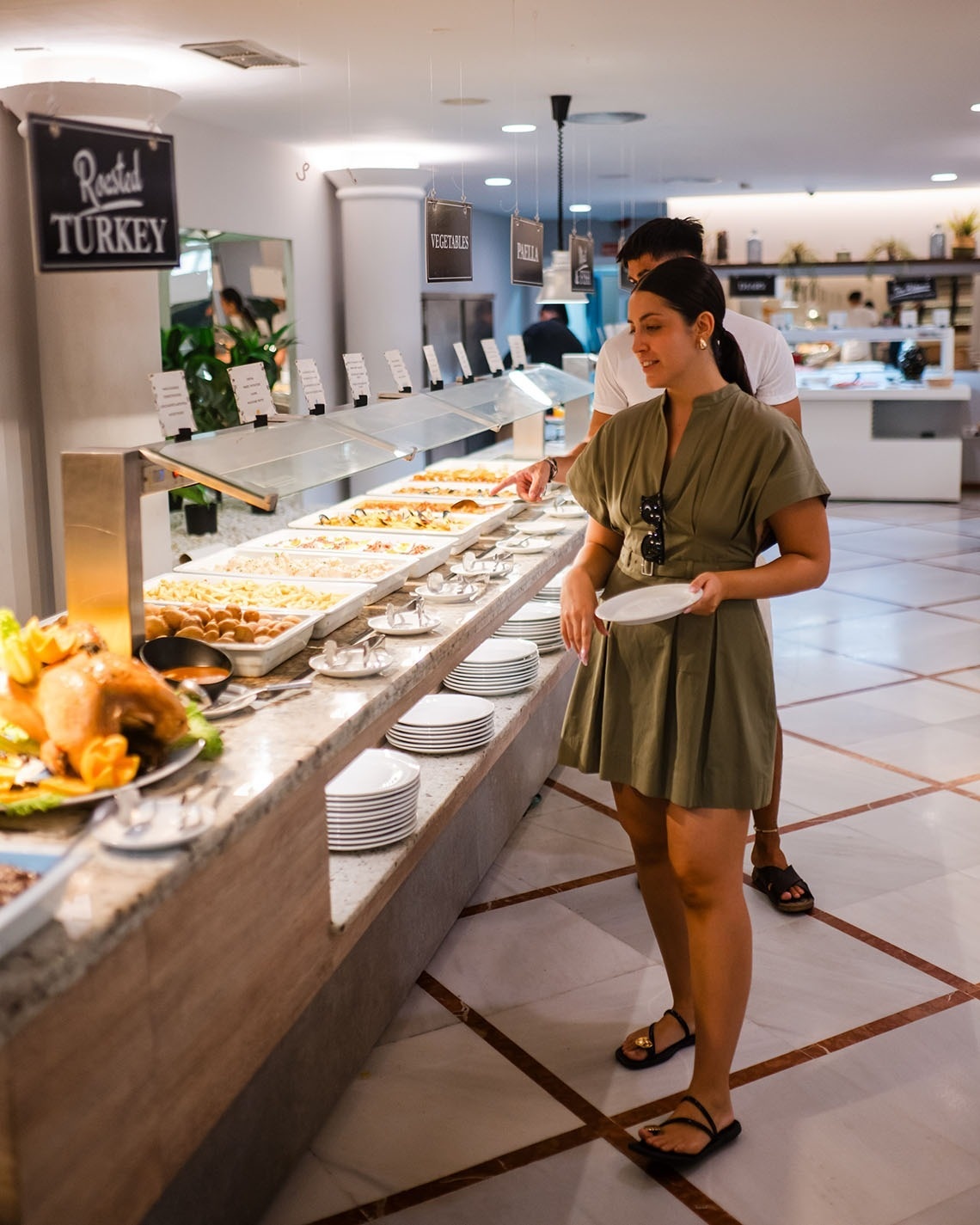 a woman is standing in front of a sign that says roasted turkey