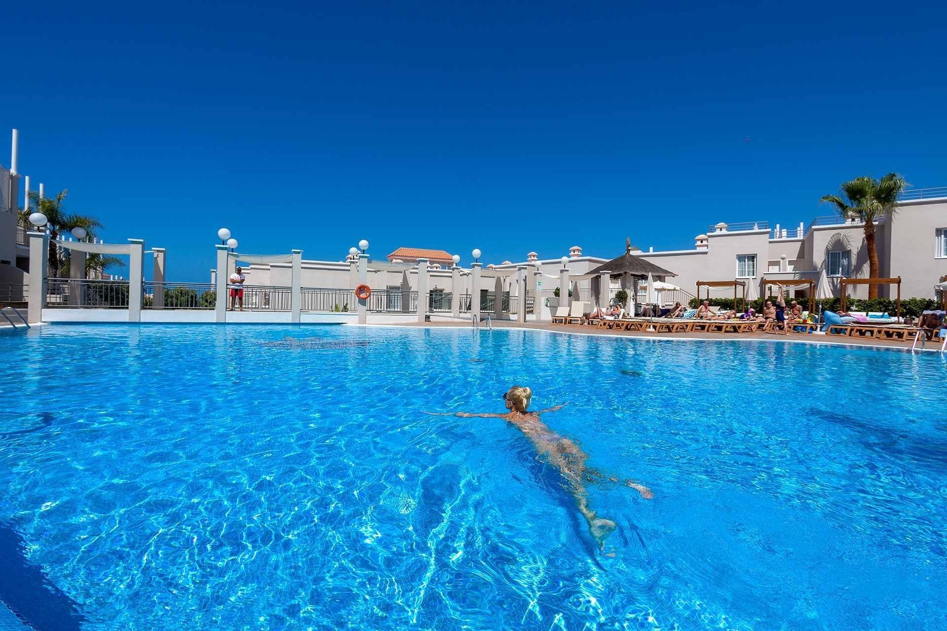 a woman is swimming in a large swimming pool