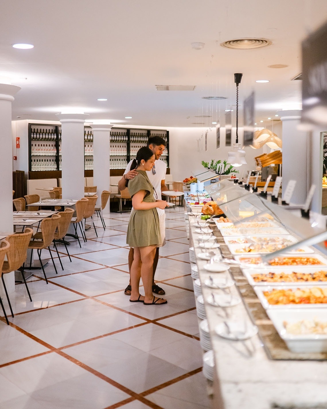 a man and a woman stand in front of a buffet line