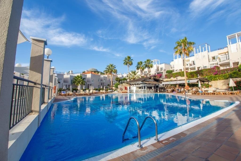 a large swimming pool with a bar in the background