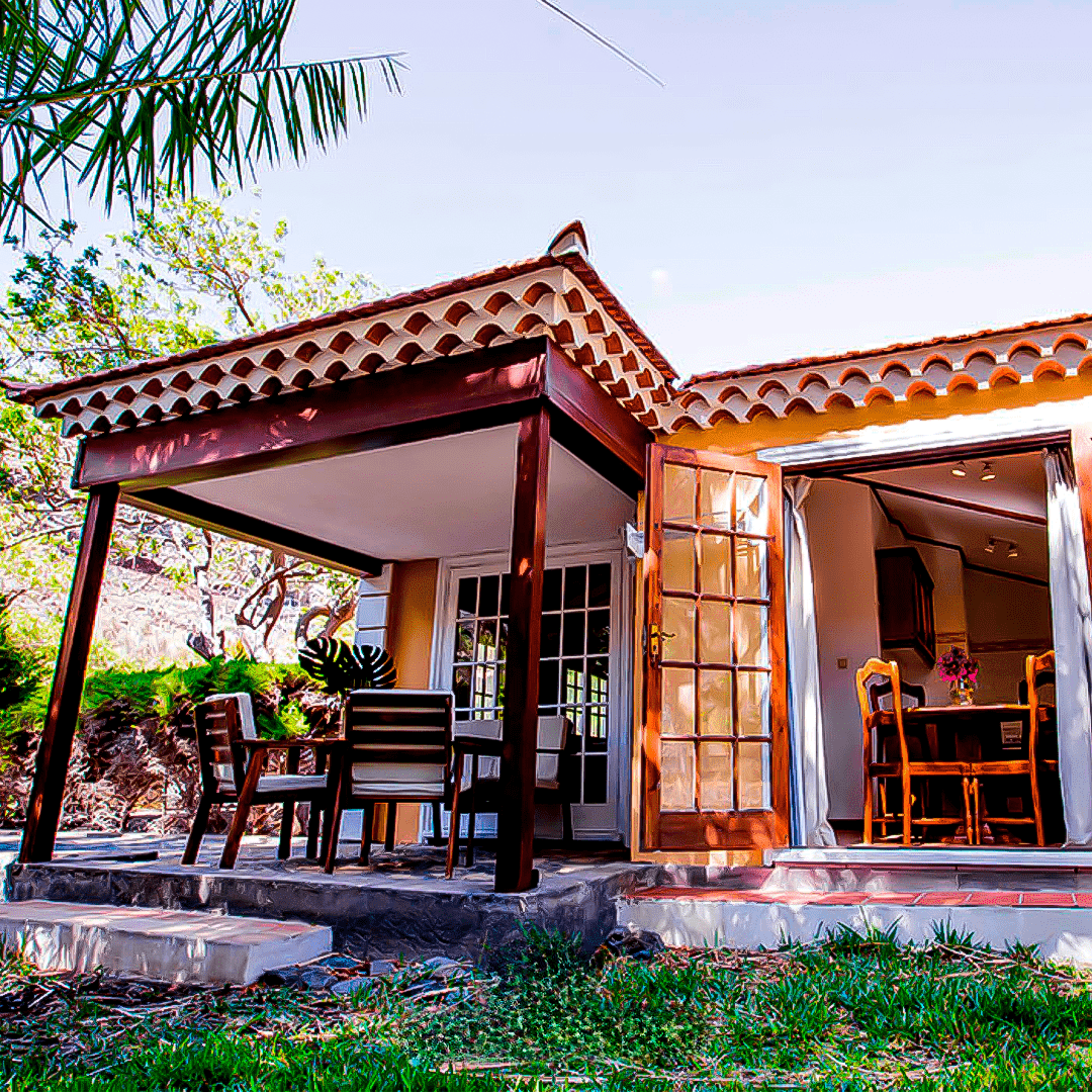 a small house with a porch and a table and chairs