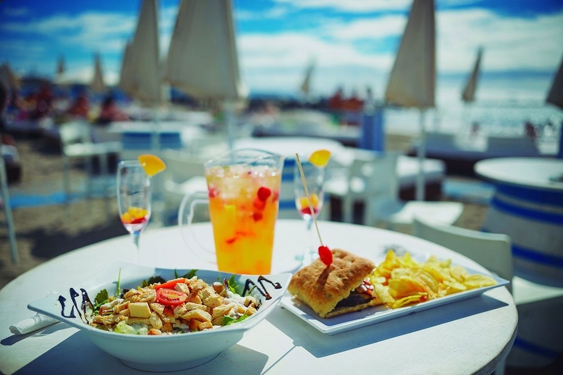 a plate of food on a table next to a drink