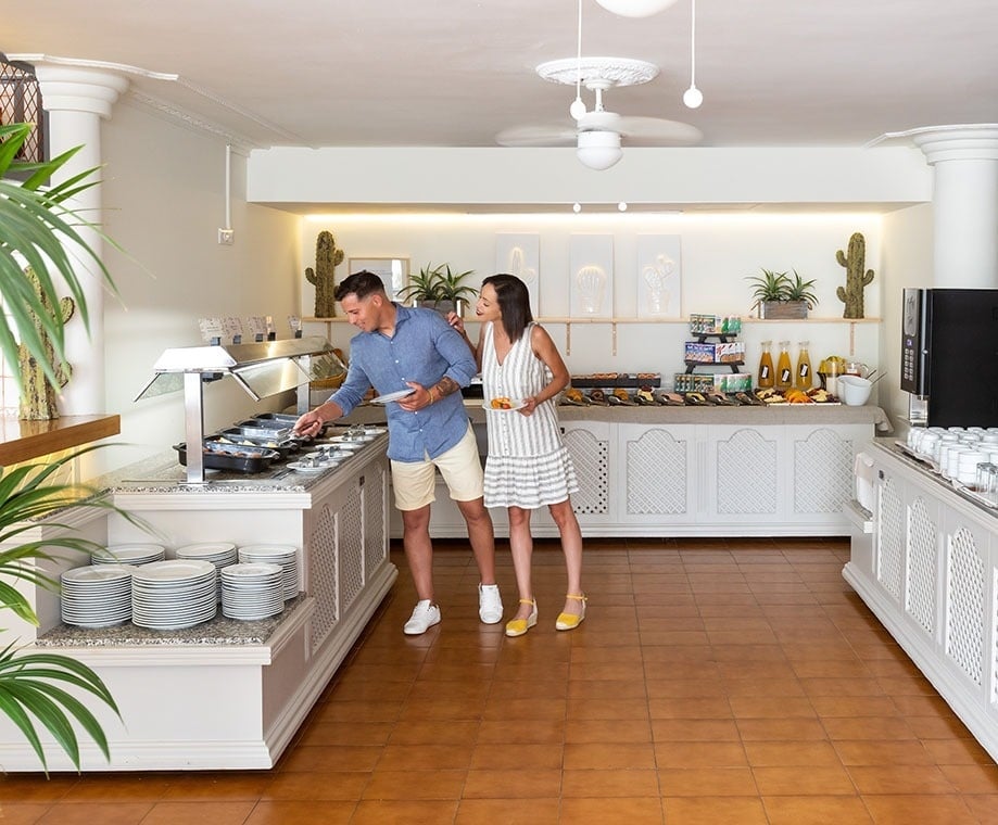 a man and a woman are standing in a buffet line