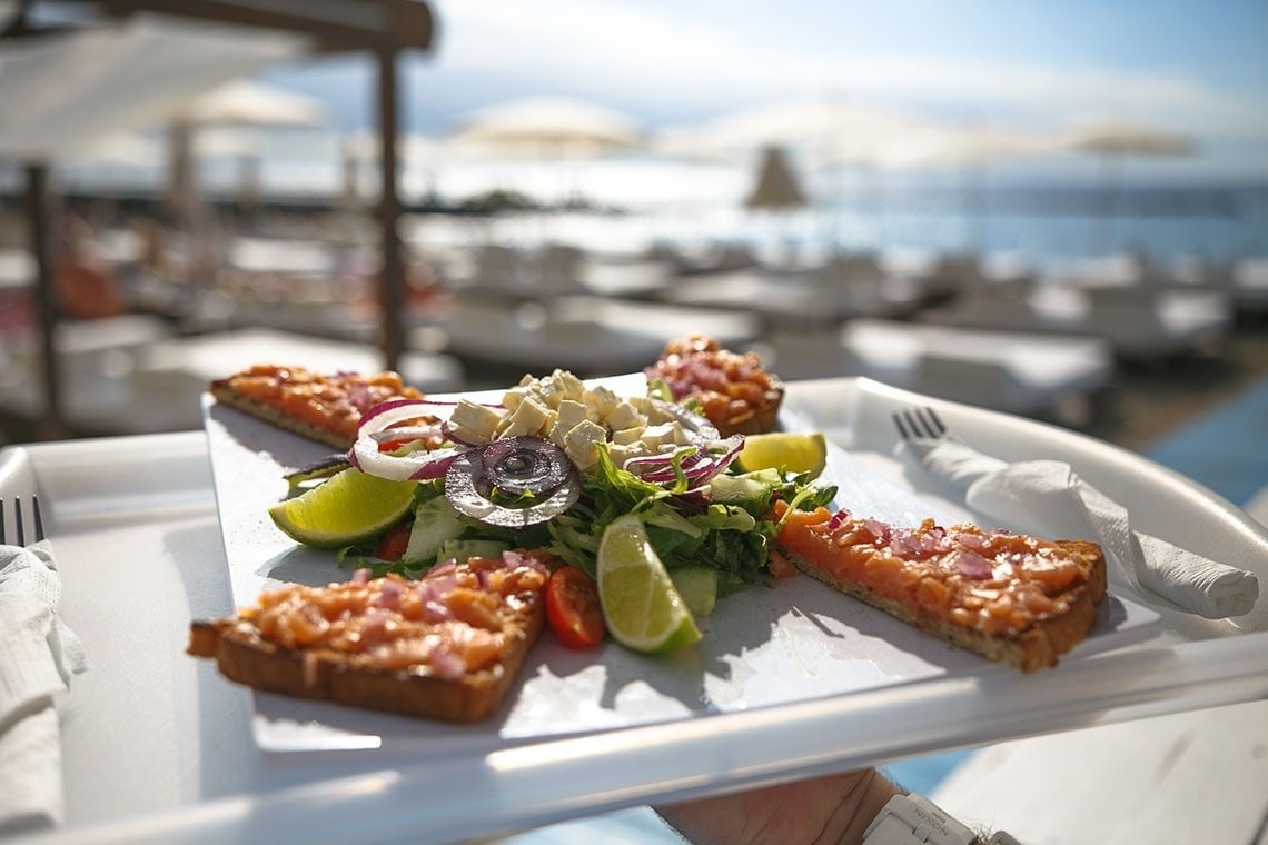 a person is holding a tray with a salad on it