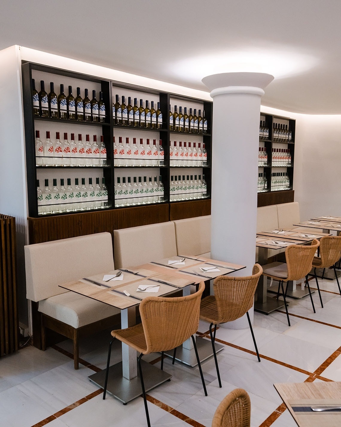 a restaurant with tables and chairs and bottles of wine on shelves