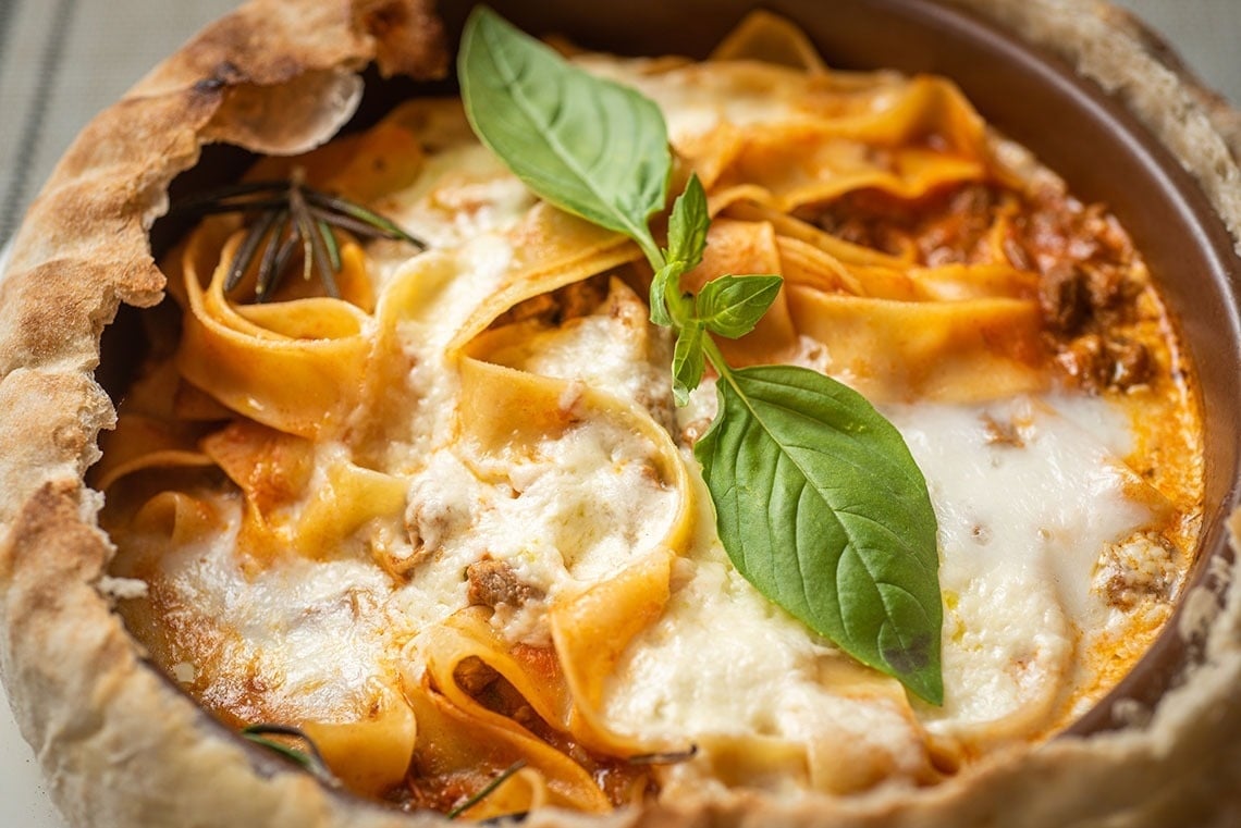 a close up of a pasta dish with basil on top