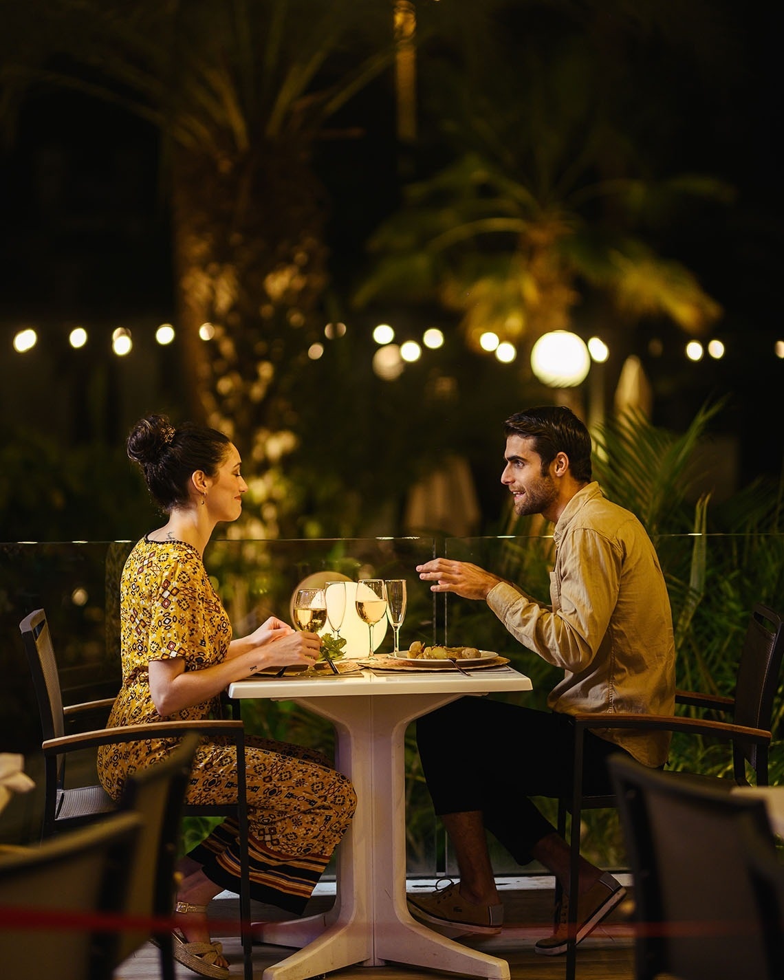 a man and a woman are sitting at a table with wine glasses