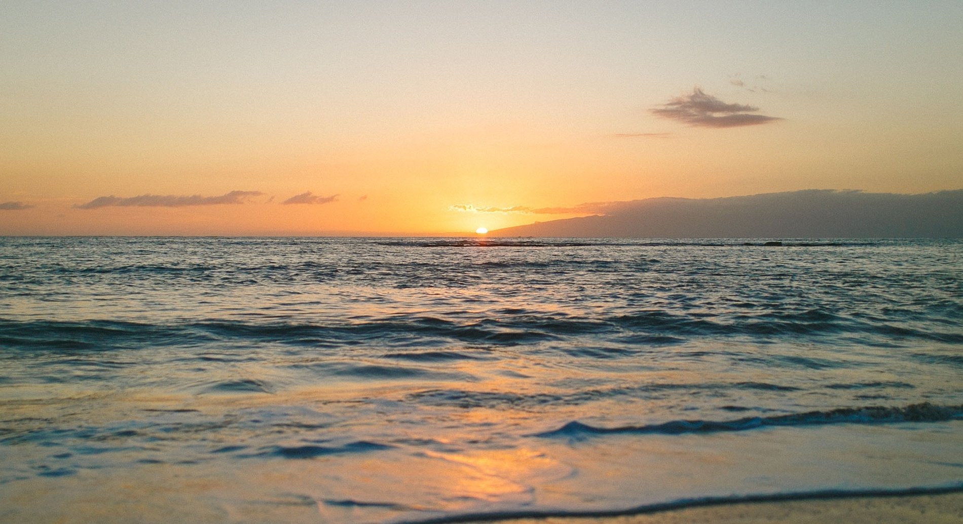 an aerial view of waves crashing on a sandy beach