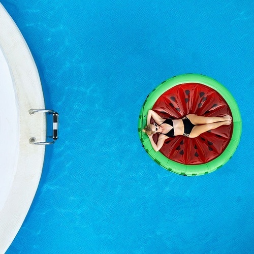 a woman is laying on a watermelon float in a pool