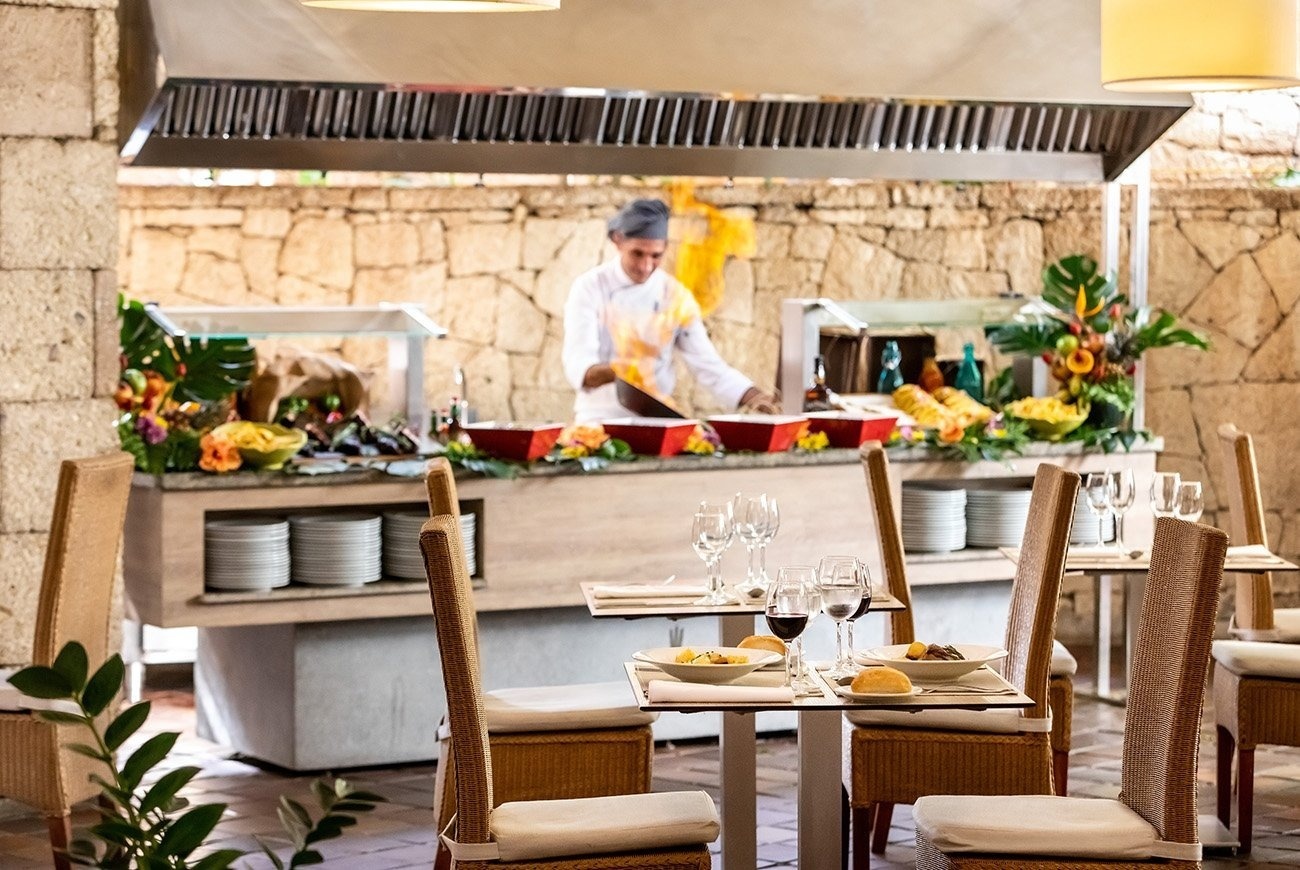 a restaurant with a chef preparing food in the background