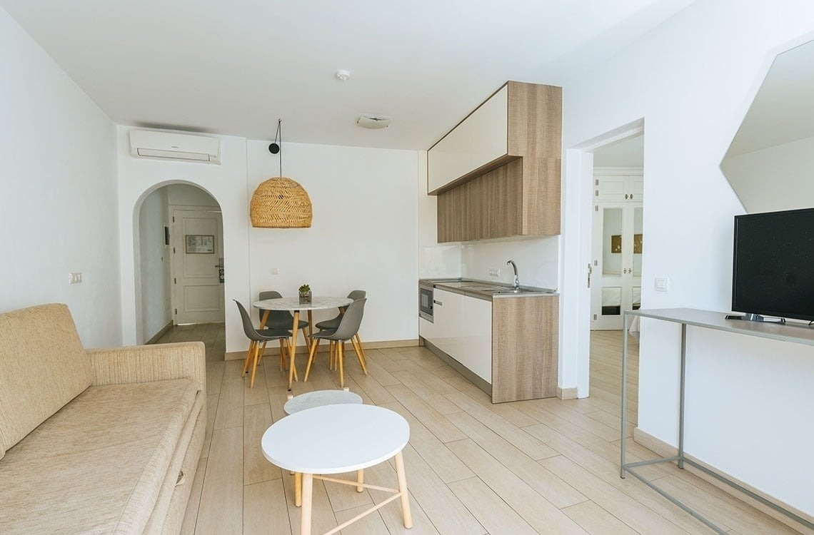 una sala de estar con una mesa y sillas y una cocina