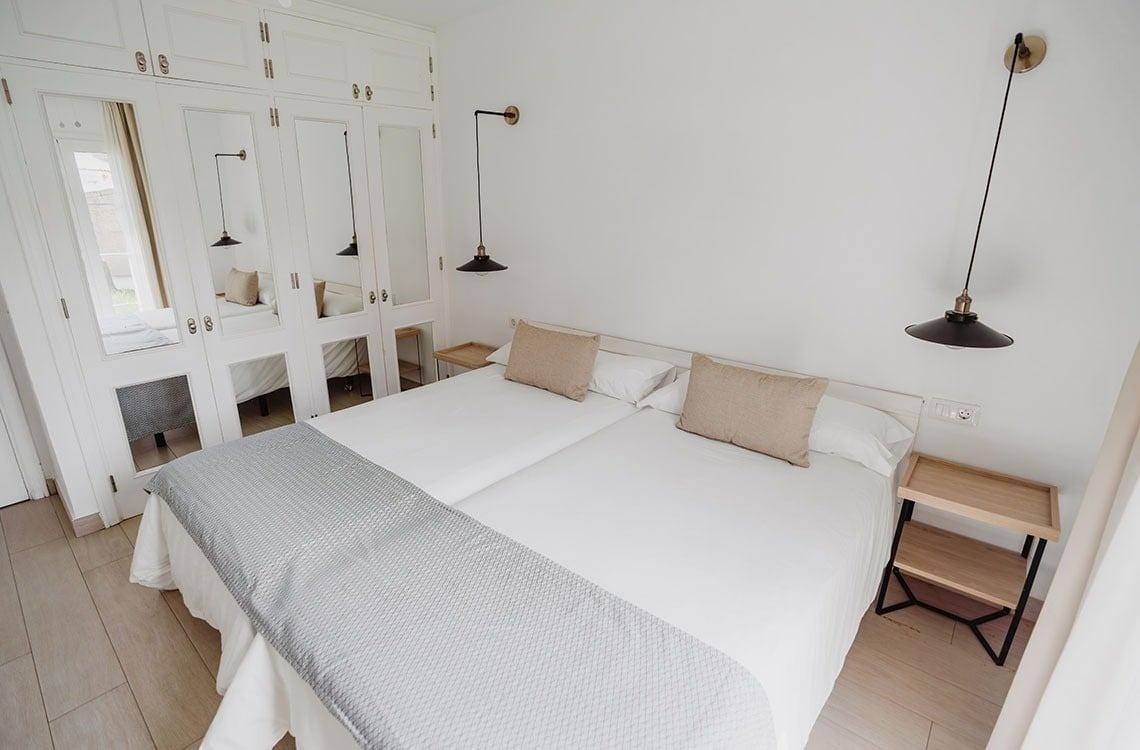 un dormitorio con dos camas y un armario con espejos